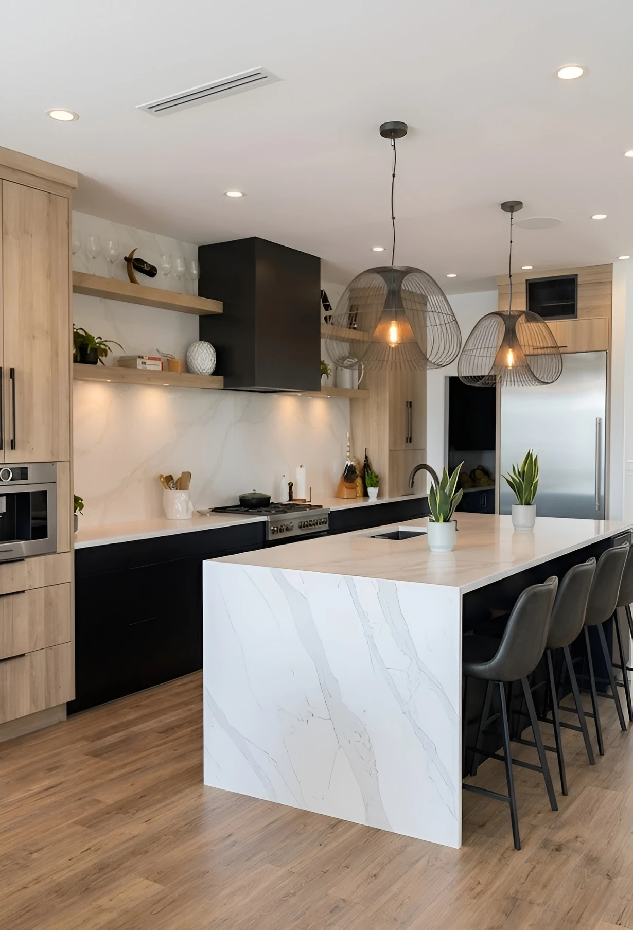 Modern kitchen with black cabinetry, white quartz waterfall island and wire pendant lights